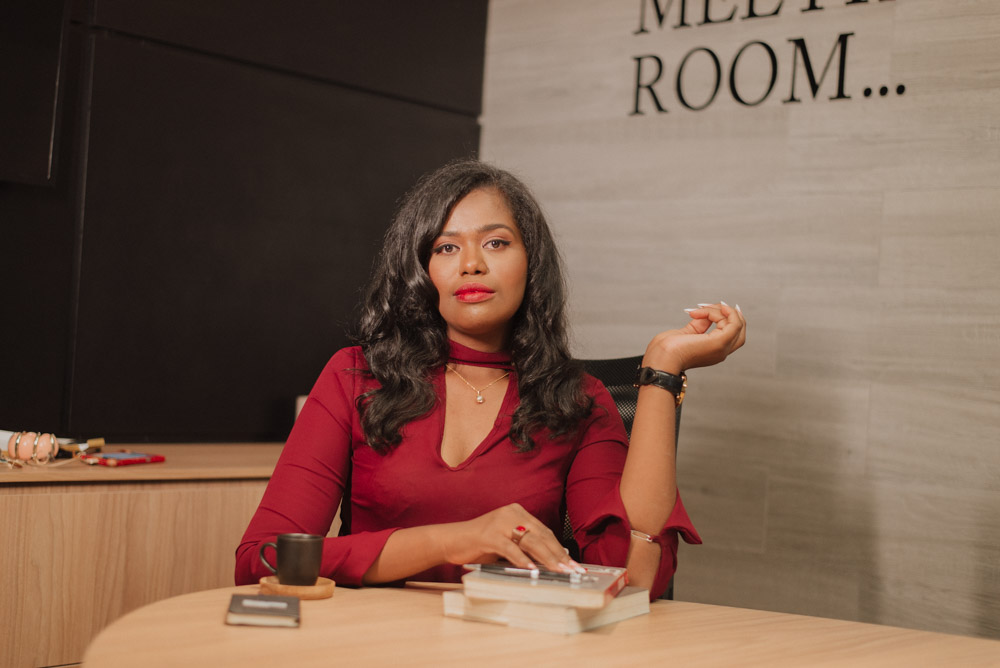 Eduarda Bispo sentada à mesa de uma sala de reuniões corporativa